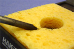 Cleanse the soldering tip with a wet sponge.